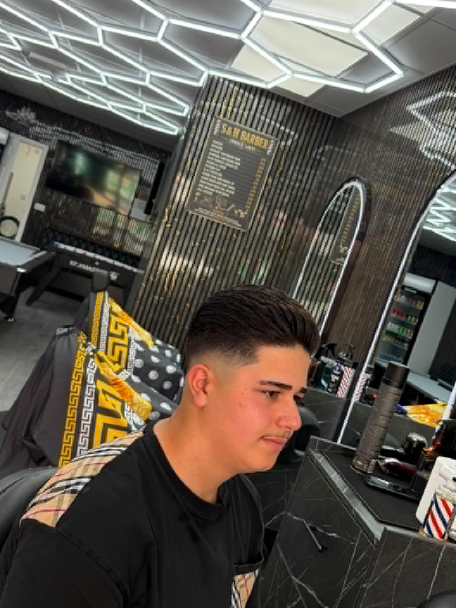 Textured top with a clean fade by S&H Barber